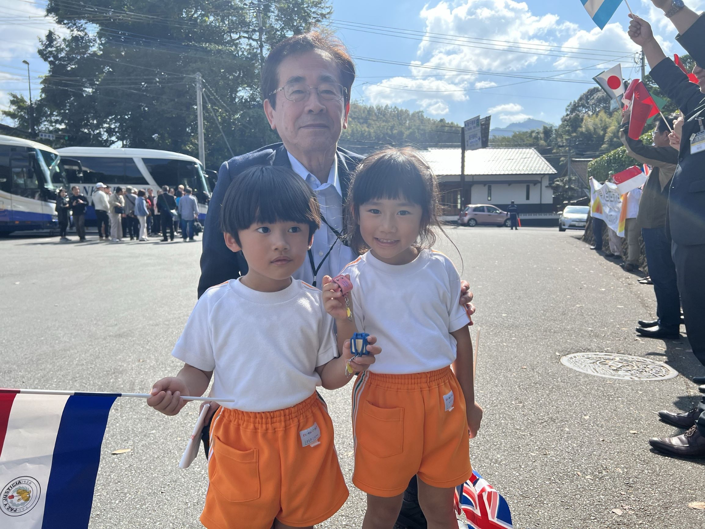 高千穂神社でツアー参加者を出迎えてくれた地元の子どもたちに参加者からプレゼントが贈られ、記念の一枚。